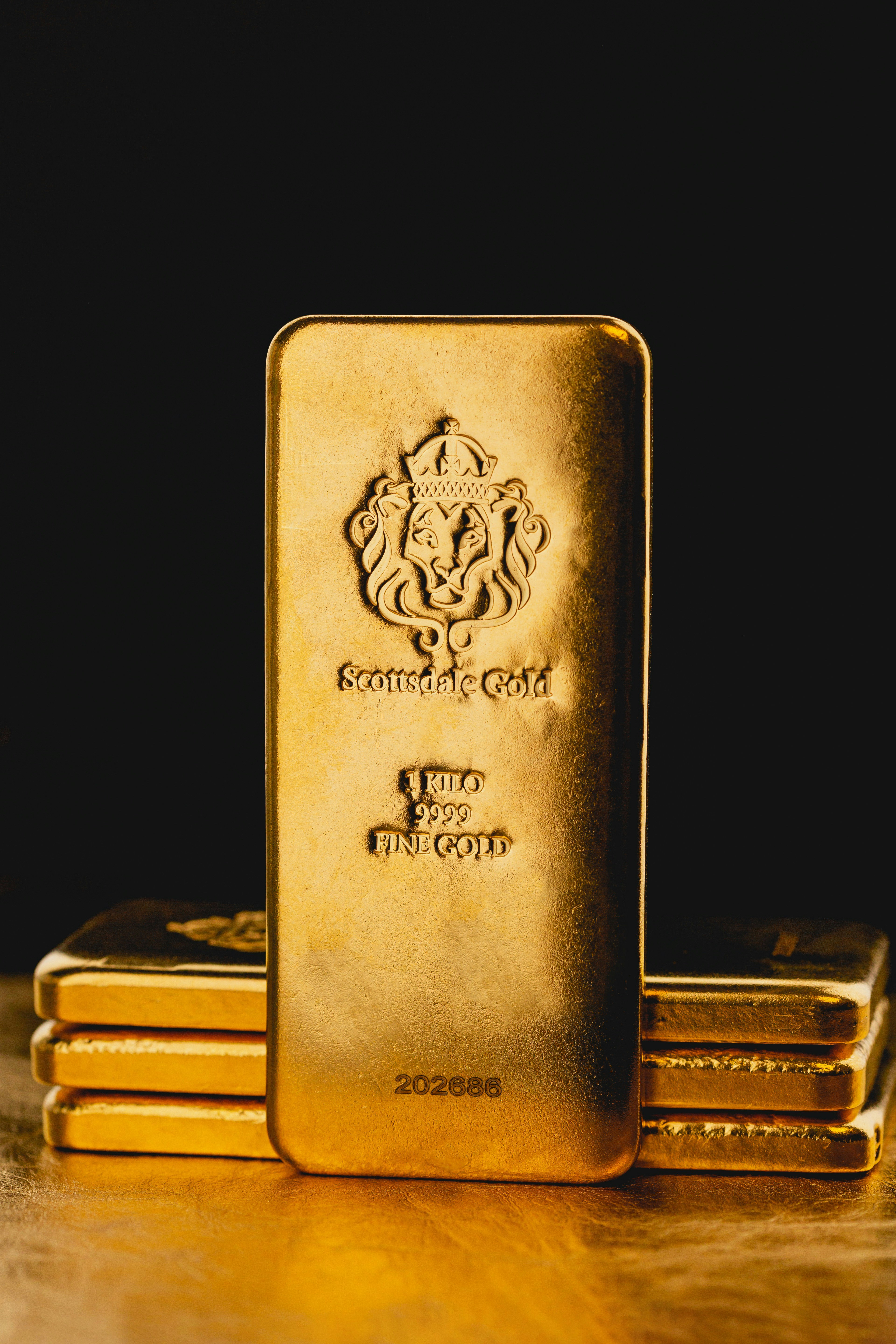 Beautiful 1 Kilogram Gold Bullion Bars by Scottsdale Mint sitting on a dark background. Please give a shoutout to Scottsdale Mint if able! Shop online for the most beautiful bullion at ScottsdaleMint.com!